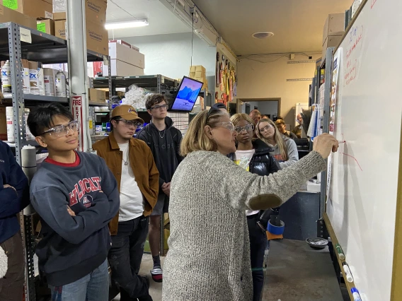 Students watching person write details on white board