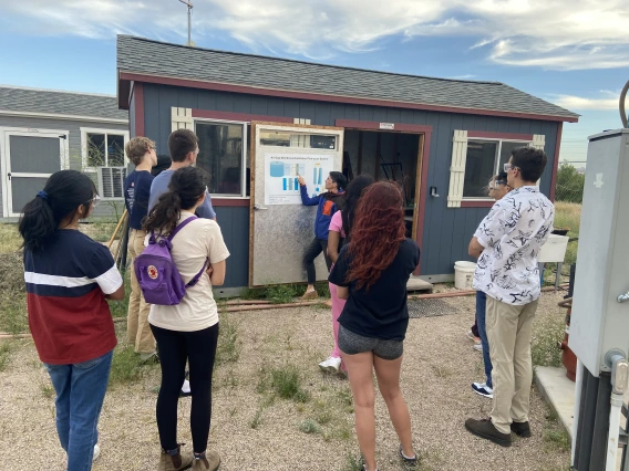 Students listening to professor explain a chart